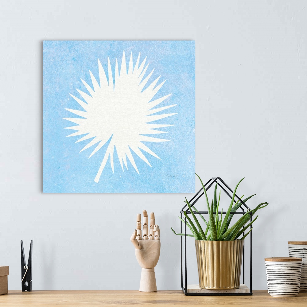 A bohemian room featuring White silhouette of a palm leaf on a blue square background.