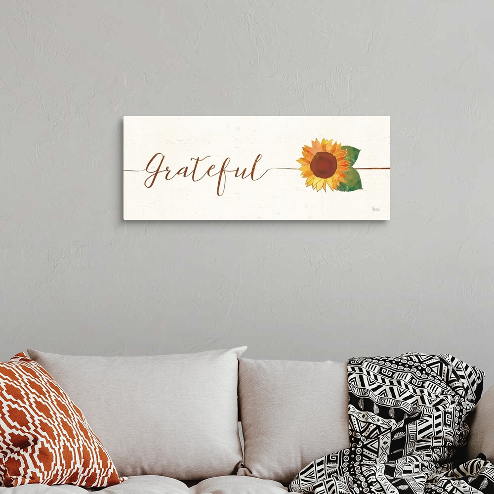 A bohemian room featuring Horizontal artwork of "Grateful" in handwritten text with a sunflower.