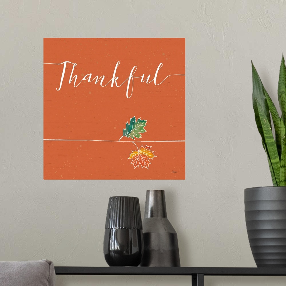 A modern room featuring "Thankful" with a pair of fall leaves on a wood textured orange background.