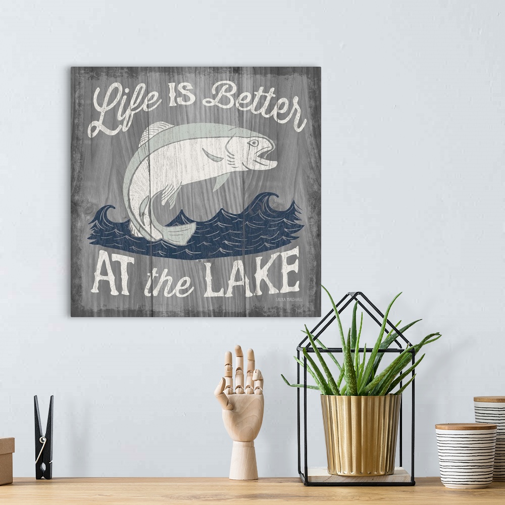 A bohemian room featuring "Life is Better at the Lake" in white with an illustration of a fish jumping out of water on a  g...