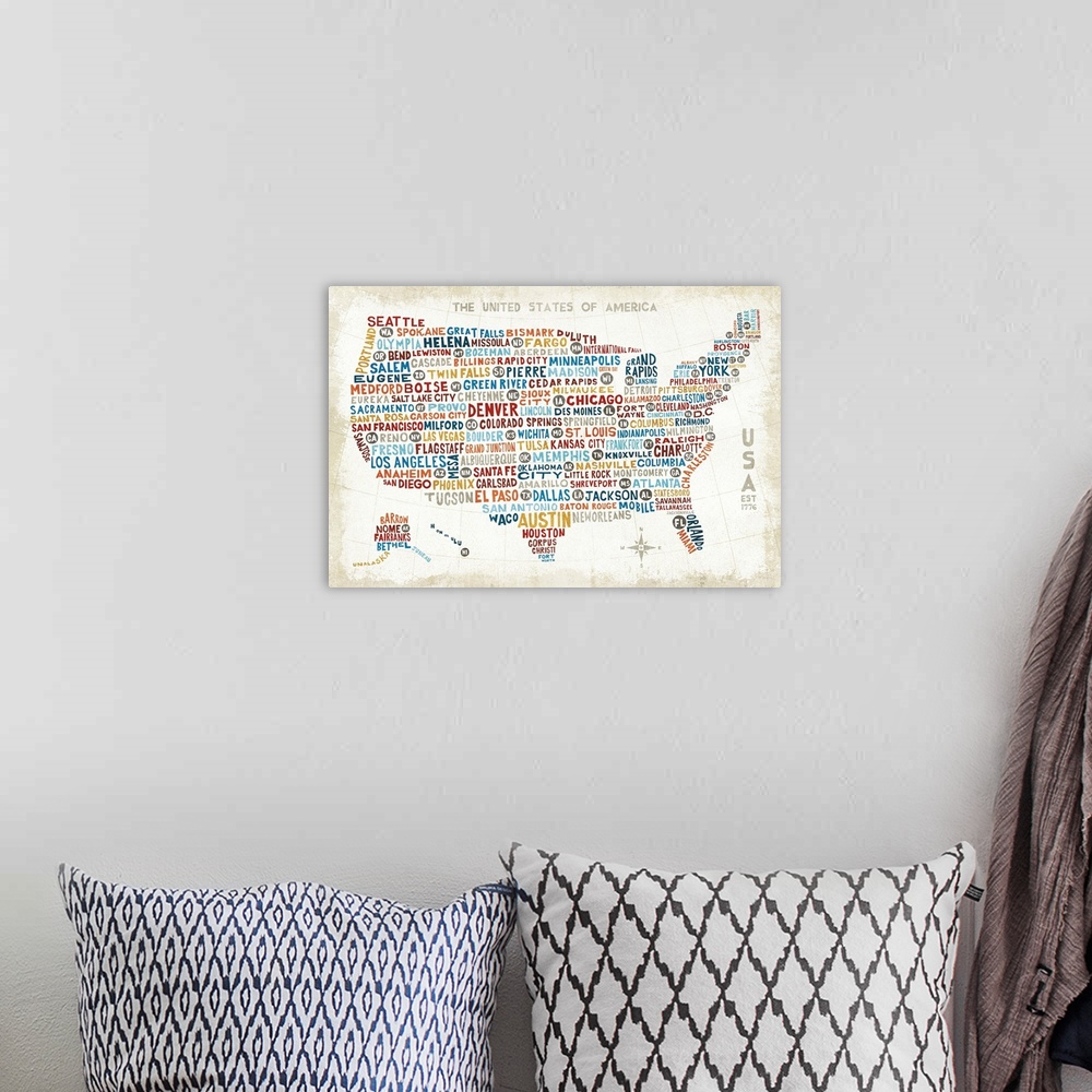 A bohemian room featuring A map of the United States with the names of large cities in colorful text.