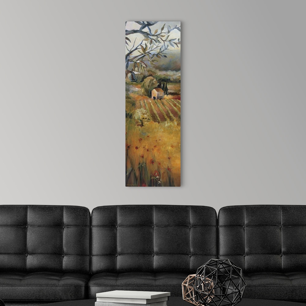 A modern room featuring Oversized, vertical panting, looking down onto a golden field in front of a vineyard, a dense tre...
