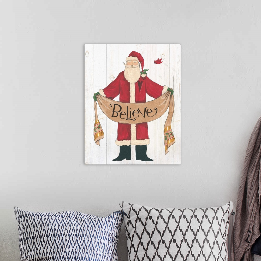 A bohemian room featuring Santa Claus holding a banner with "believe" on a white wood plank backdrop.