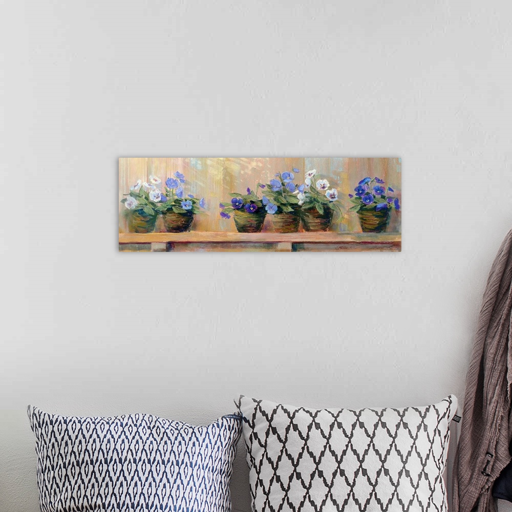 A bohemian room featuring Panoramic floral art shows six potted flowers of varying color as they sit quietly on a shelf.
