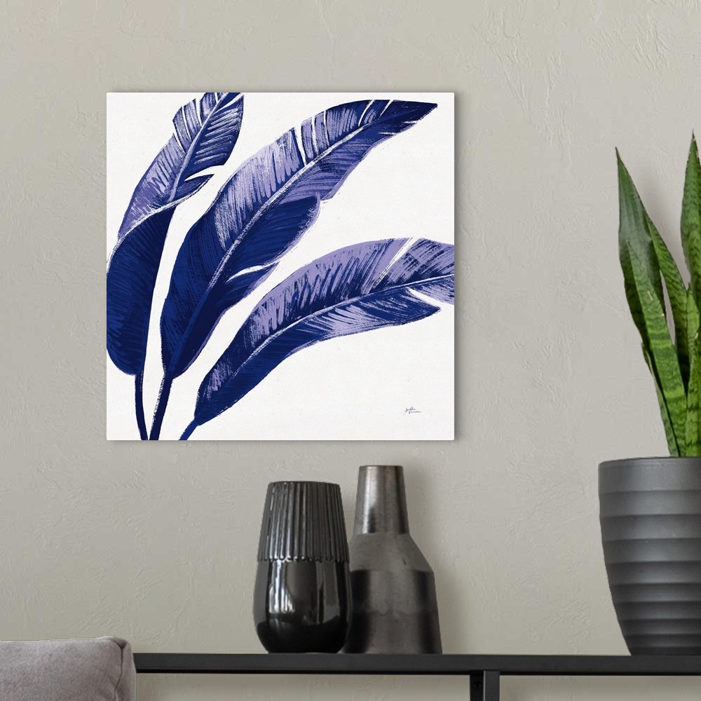 A modern room featuring Square decorative artwork of large palm leaves in shades of blue.