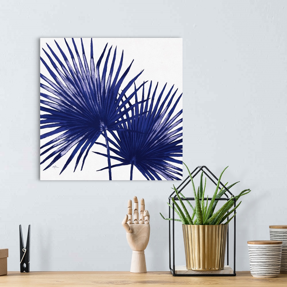 A bohemian room featuring Square decorative artwork of a large palm branch in shades of blue.