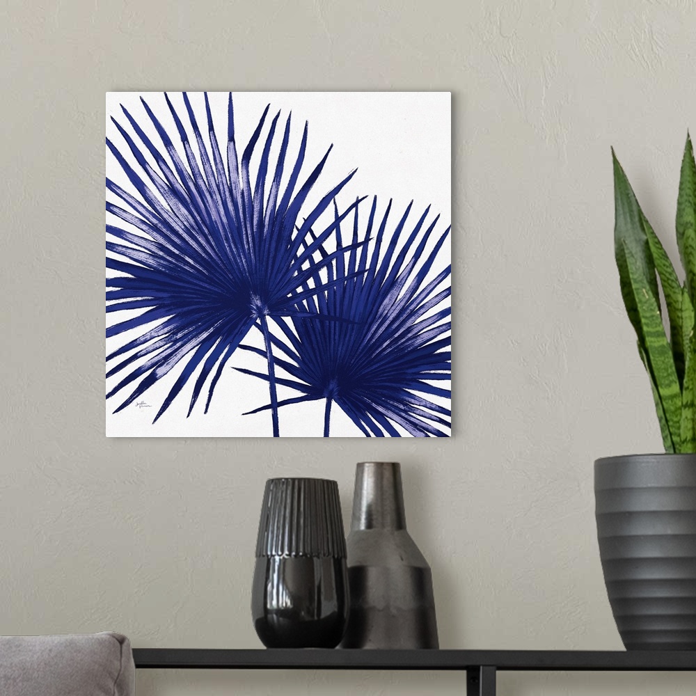 A modern room featuring Square decorative artwork of a large palm branch in shades of blue.