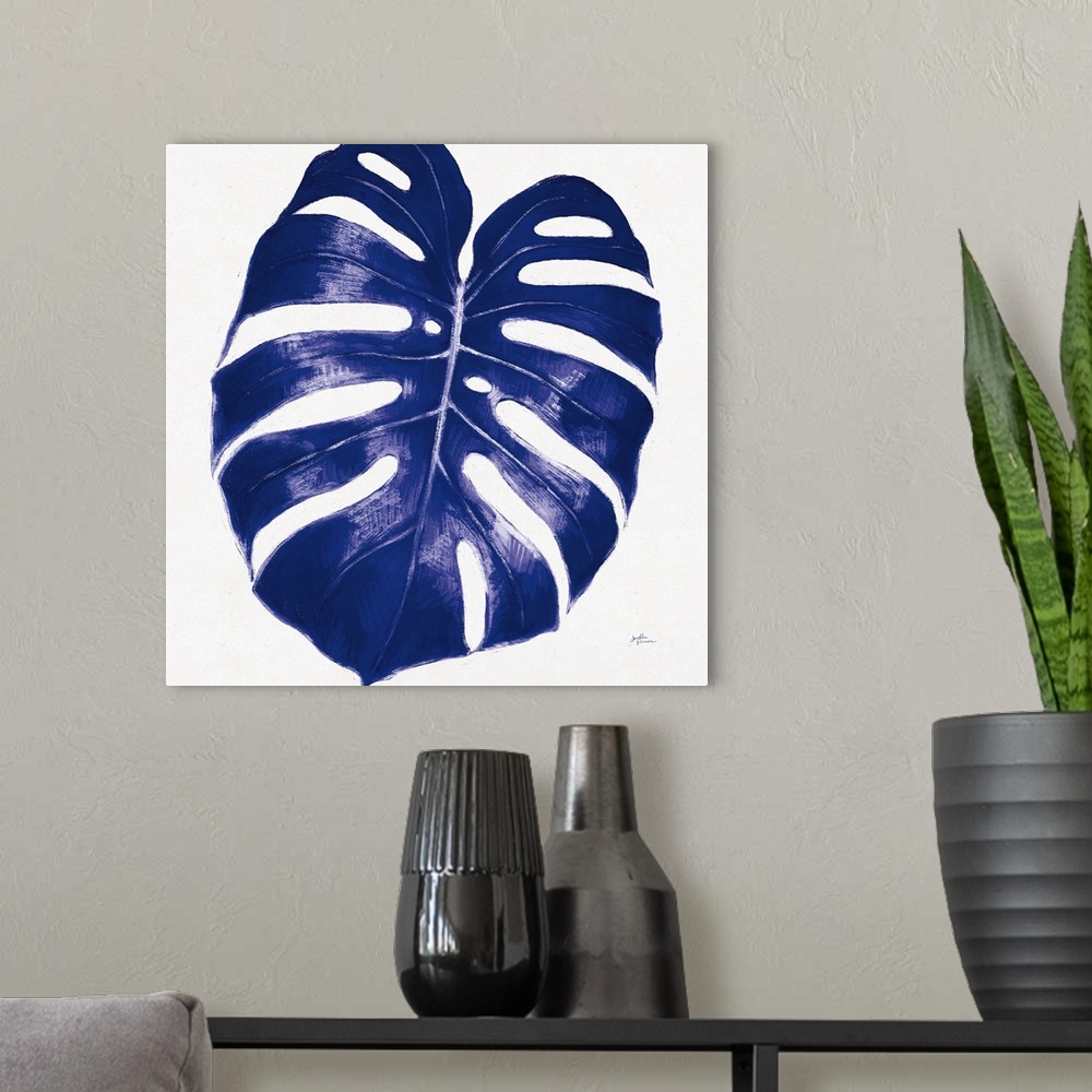 A modern room featuring Square decorative artwork of a large palm leaf in shades of blue.