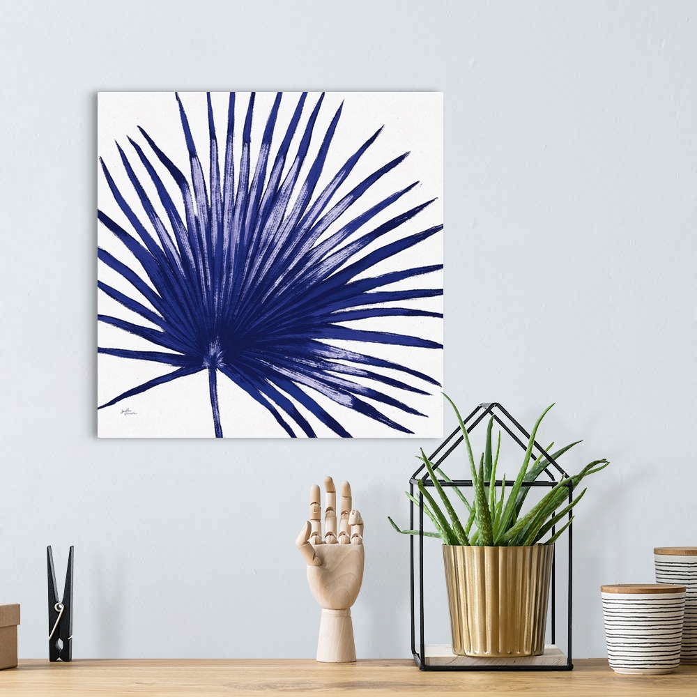 A bohemian room featuring Square decorative artwork of a large palm leaf in shades of blue.