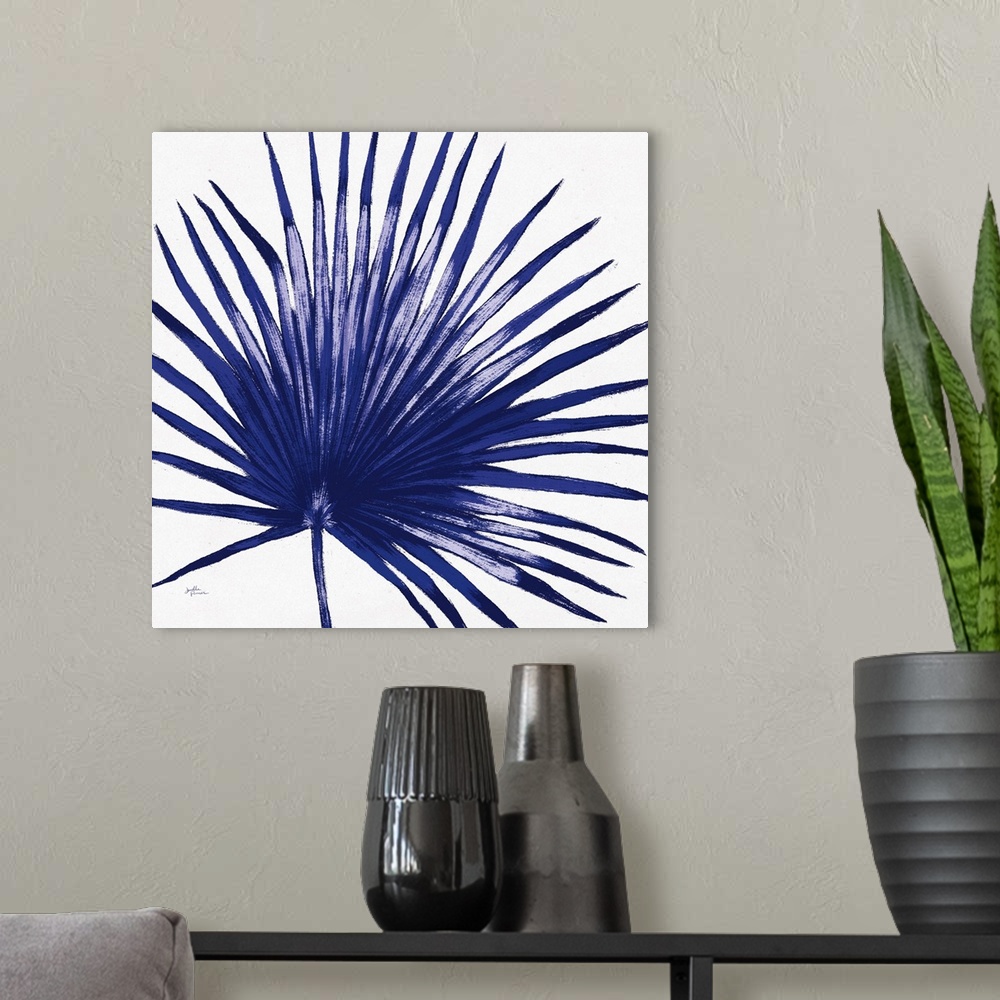 A modern room featuring Square decorative artwork of a large palm leaf in shades of blue.