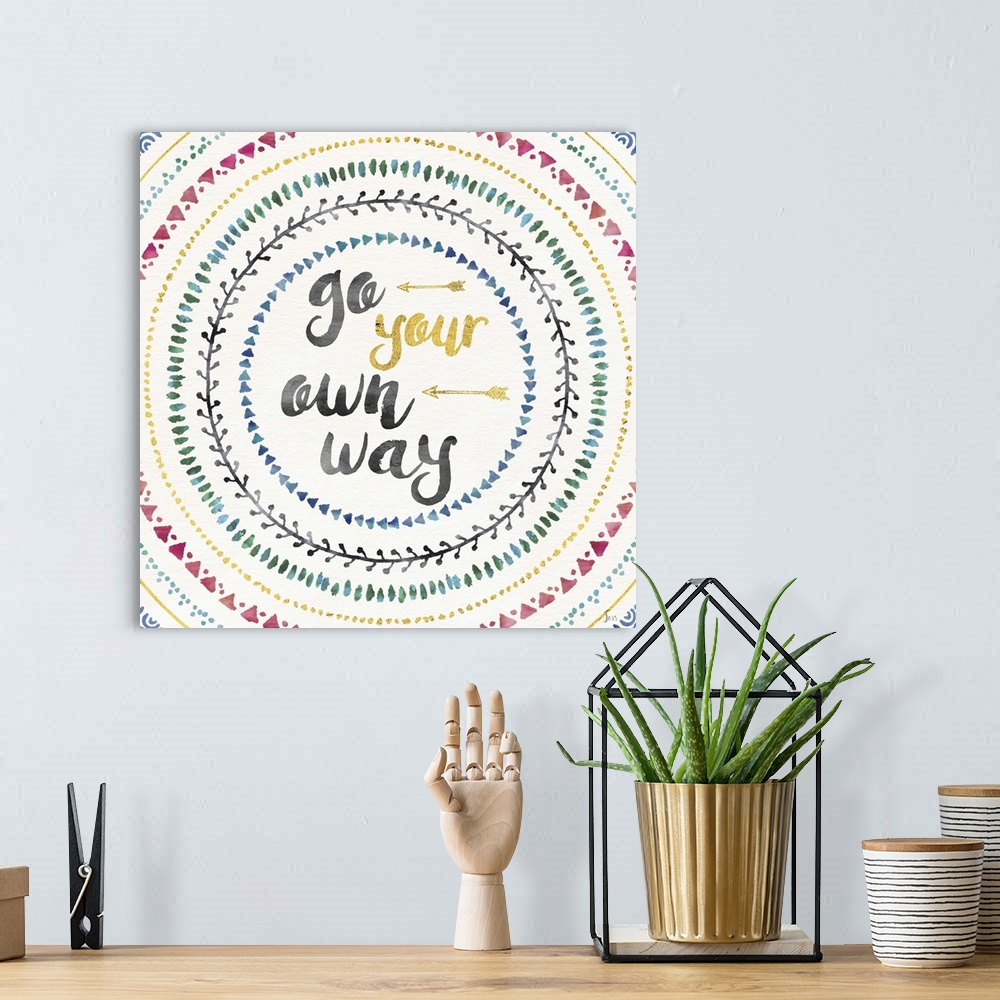 A bohemian room featuring Colorful mandala watercolor painting with the phrase "Go Your Own Way" in the center with two gol...