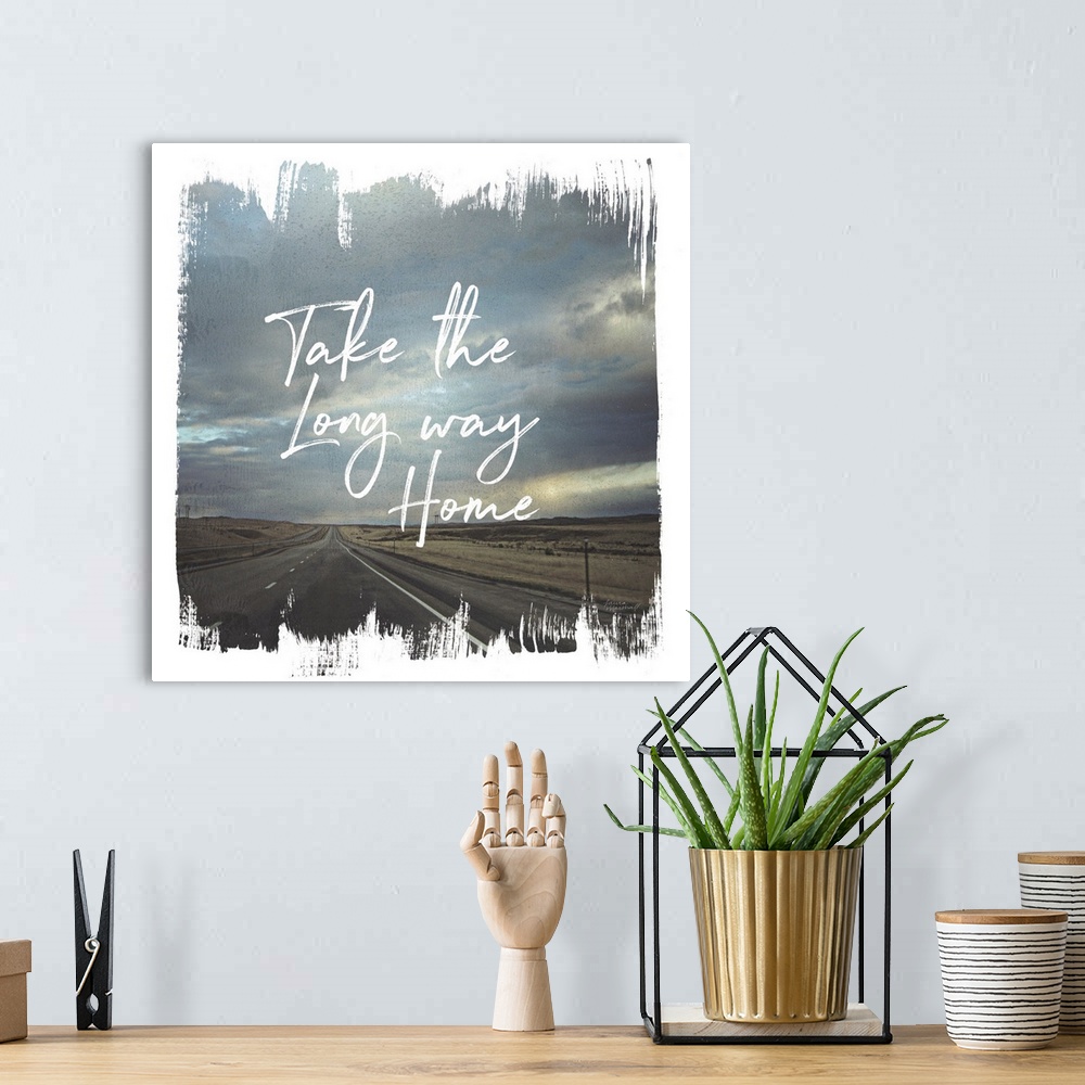 A bohemian room featuring "The the Long Way Home" written on top of a photograph of a long road and cloudy sky with brushst...