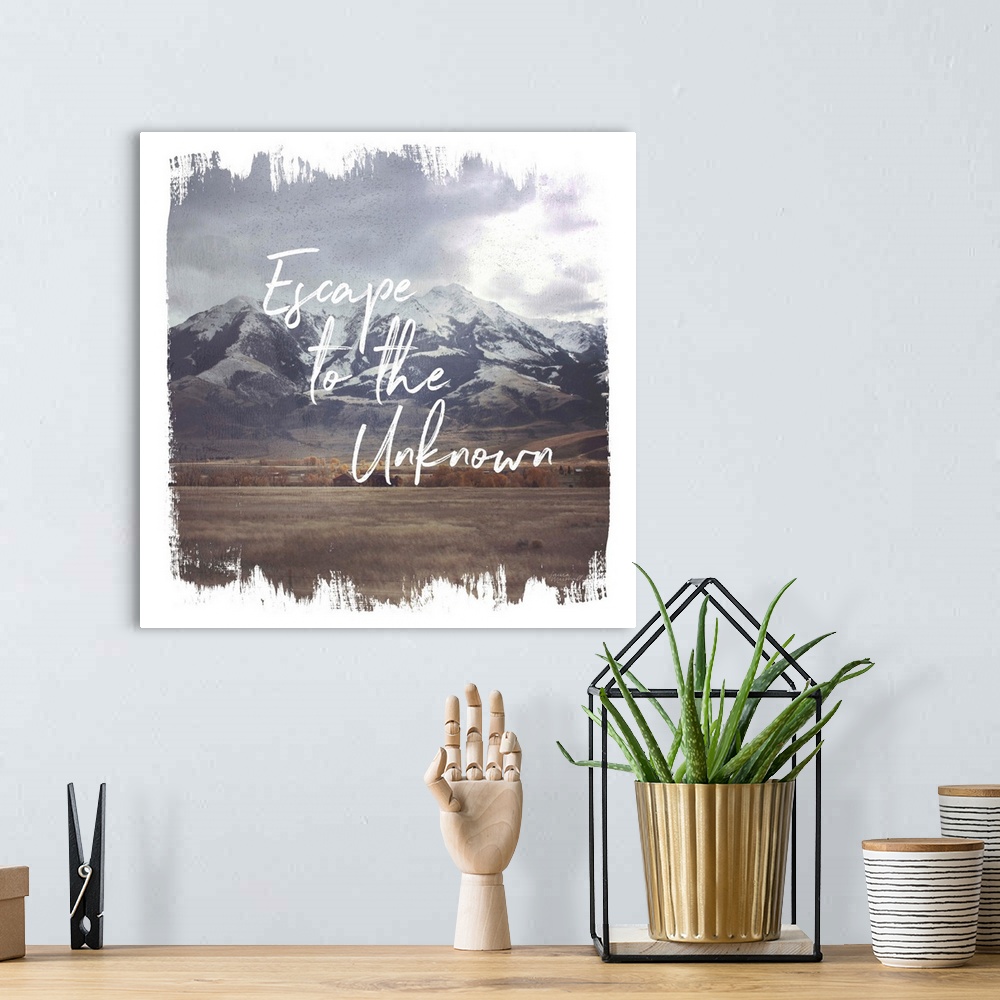 A bohemian room featuring "Escape to the Unknown" written on top of a photograph of snow capped mountains with brushstroke ...