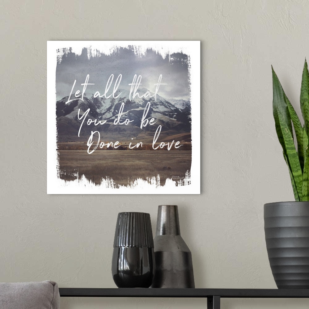 A modern room featuring "Let All That You Do Be Done In Love" in white over an image of a mountain scene and a rough edge...