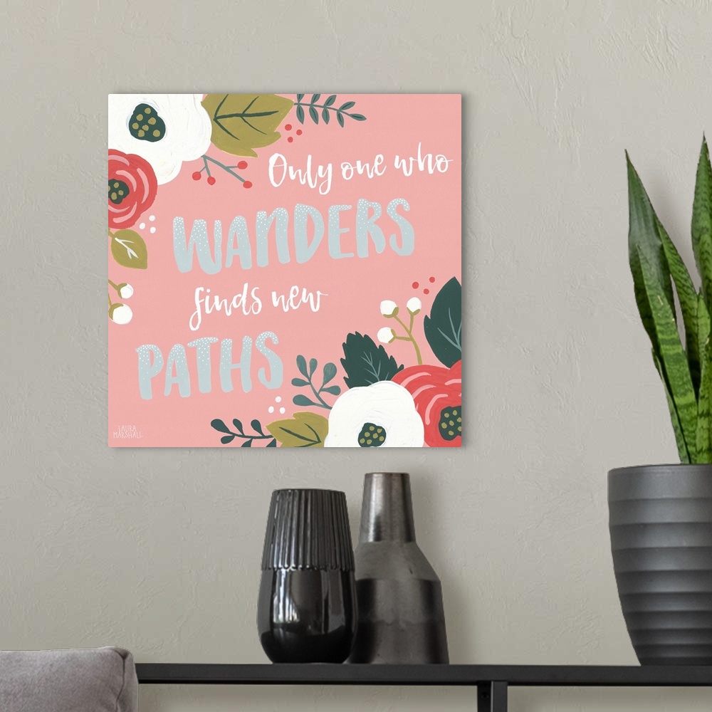 A modern room featuring "Only One Who Wanders Finds New Paths" framed by flowers on a pink background.