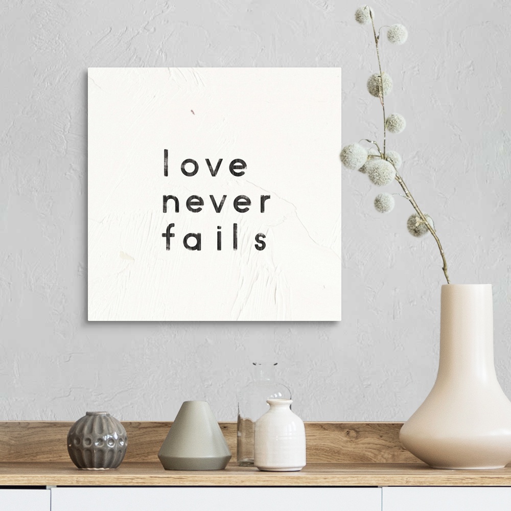 A farmhouse room featuring "Love Never Fails" written on a painted white texture background.