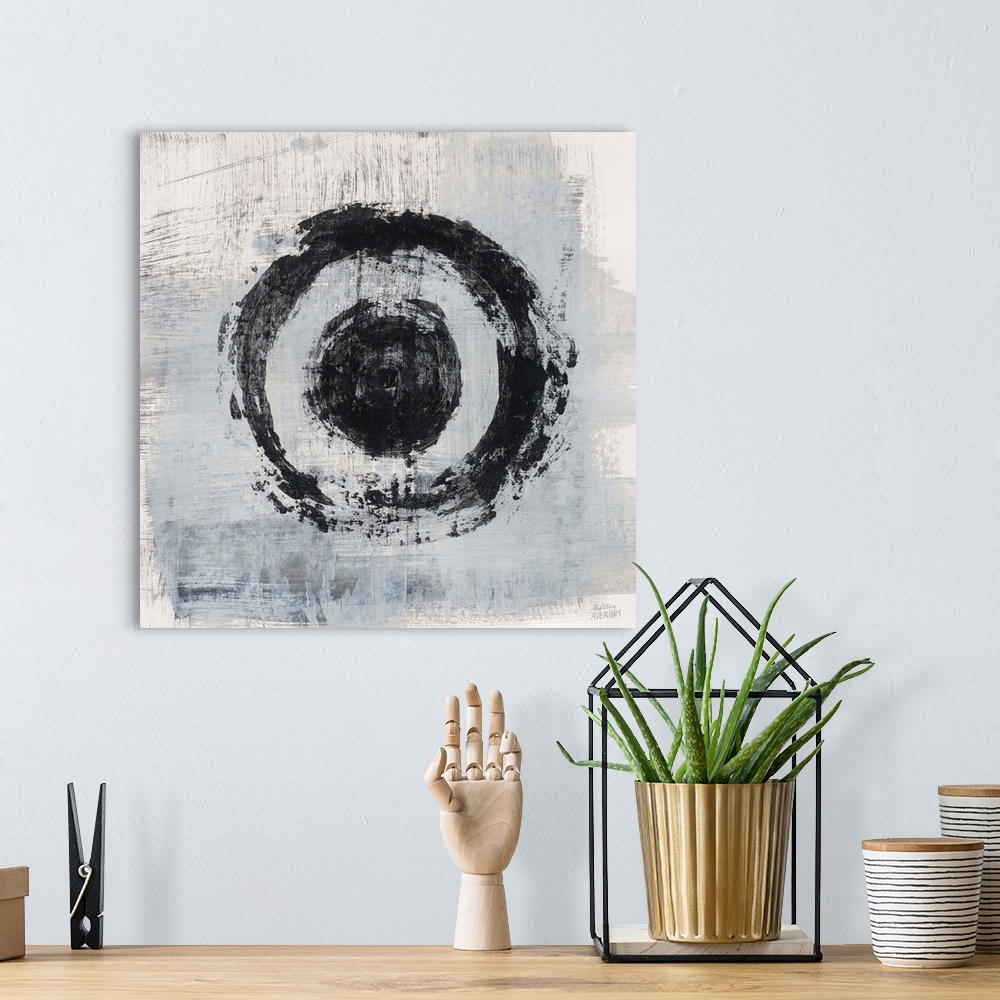 A bohemian room featuring Square abstract painting of two bold, black circles on a gray and white background.