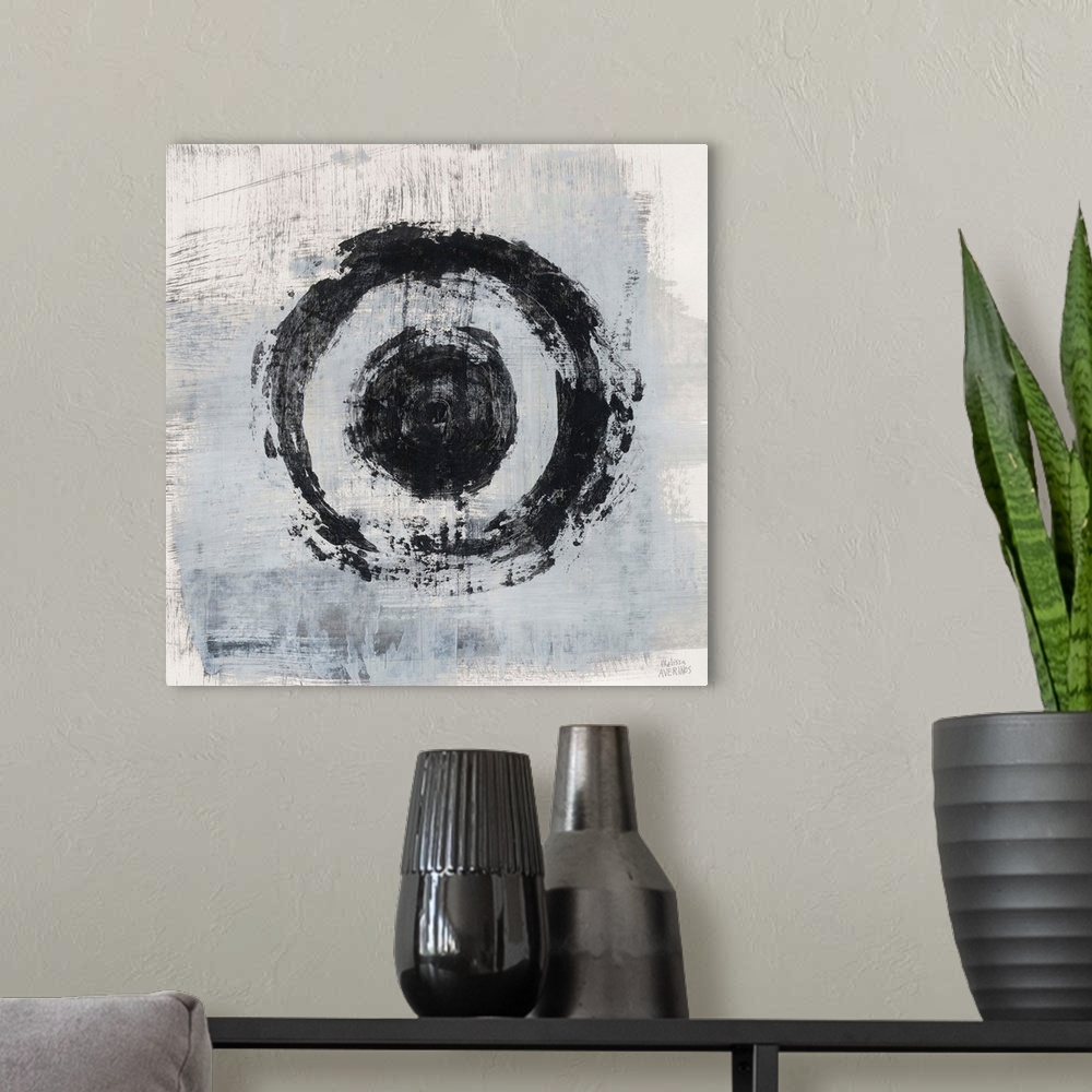 A modern room featuring Square abstract painting of two bold, black circles on a gray and white background.