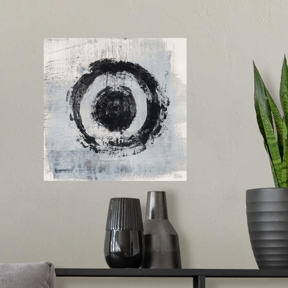 A modern room featuring Square abstract painting of two bold, black circles on a gray and white background.