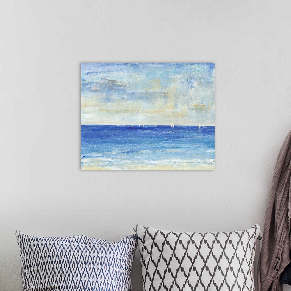 A bohemian room featuring Seascape painting of a deep blue ocean with small white sailboats on the horizon.