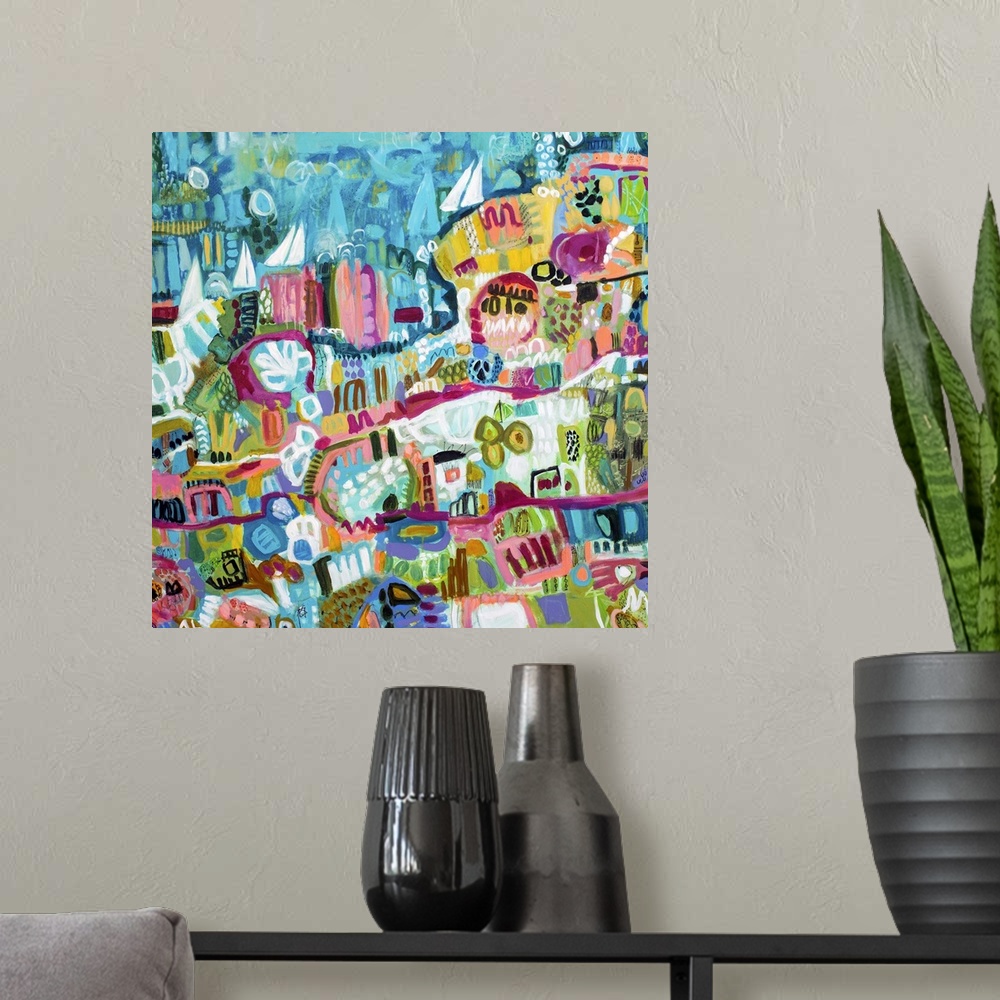 A modern room featuring Contemporary artwork of an aerial view of a beachside town and ocean with sailboats in the water.