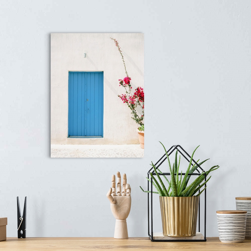 A bohemian room featuring Photograph of a simple, rustic blue door in a mediterranean building, with a planter of tall pink...