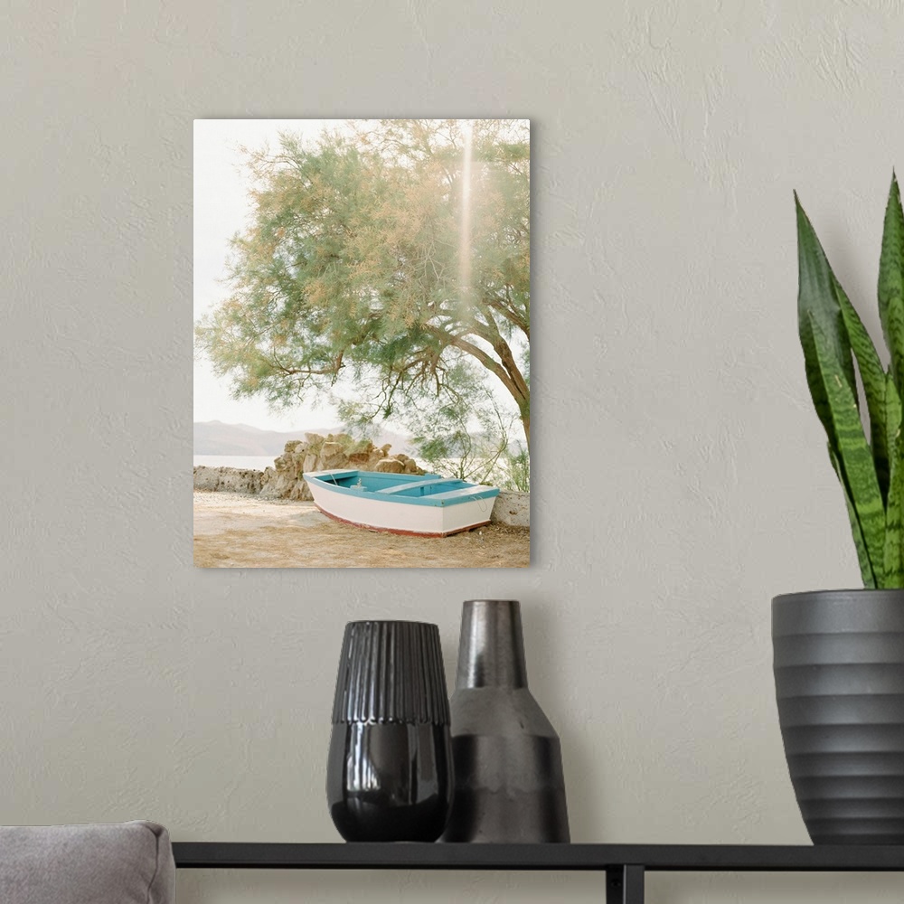 A modern room featuring Photograph of a small wooden boat underneath a tree next to the water, Milos, Greece.