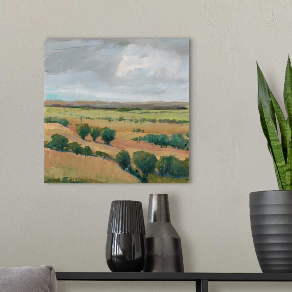 A modern room featuring Contemporary landscape painting of hills dotted with trees under a cloudy sky.