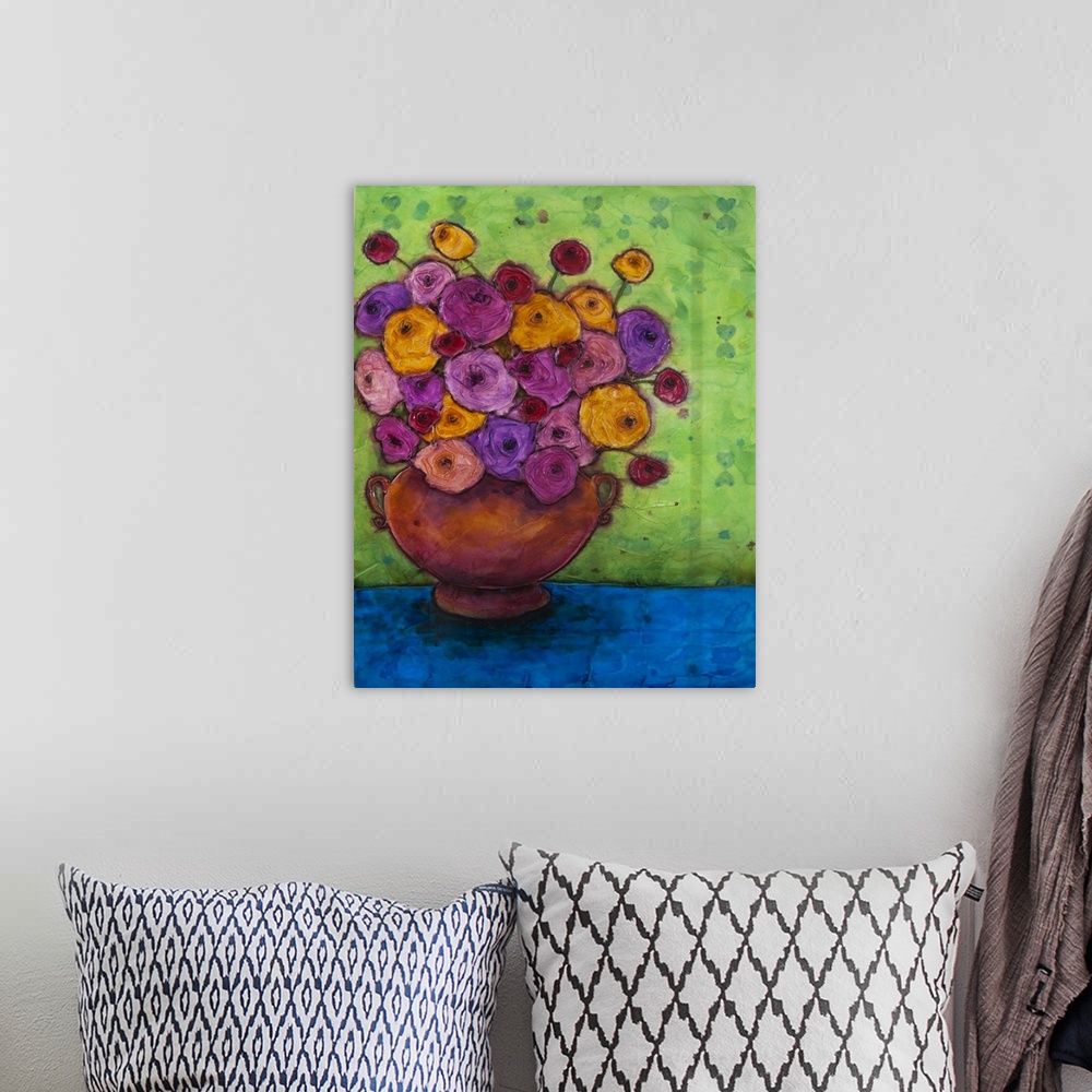 A bohemian room featuring A painting of a red vase holding a bouquet of purple and yellow flowers.