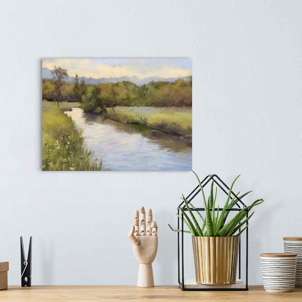 A bohemian room featuring Contemporary painting of a river cutting through a green countryside.