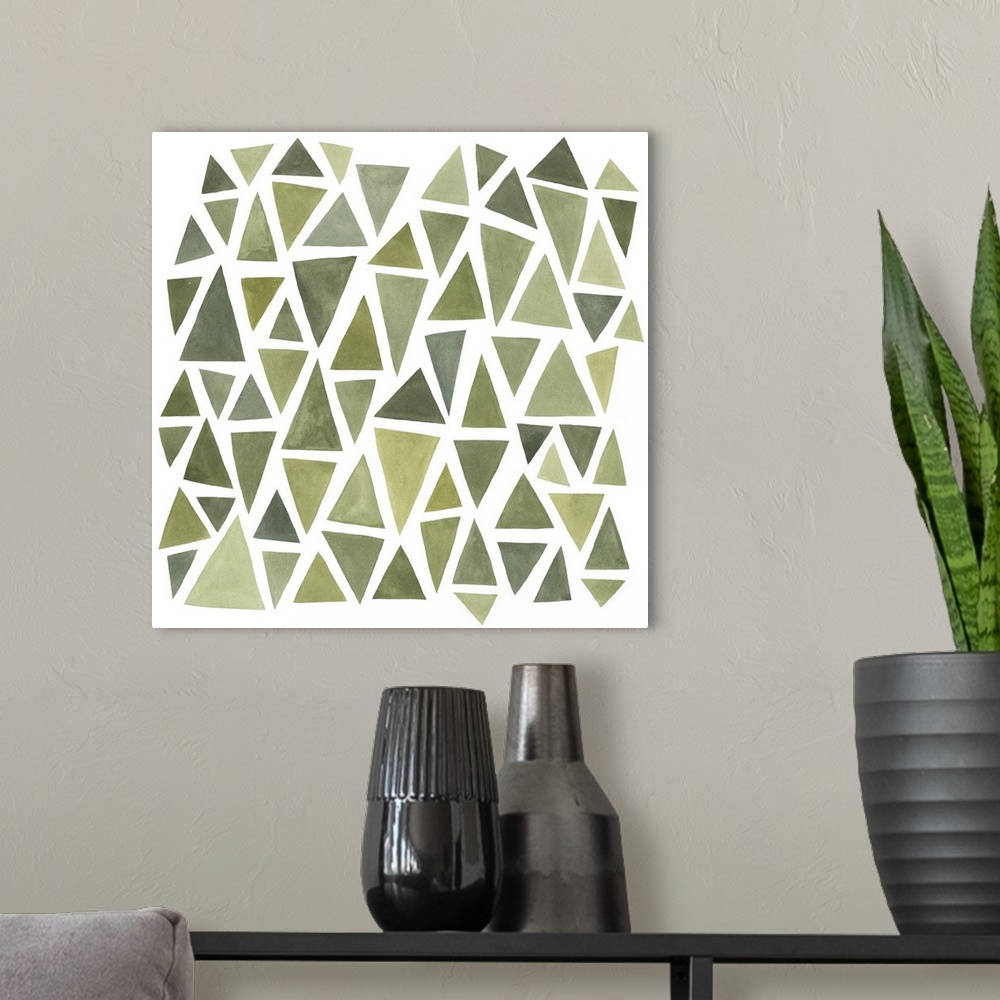 A modern room featuring A square decorative image of different sized triangles in varies shades of green on a white backg...