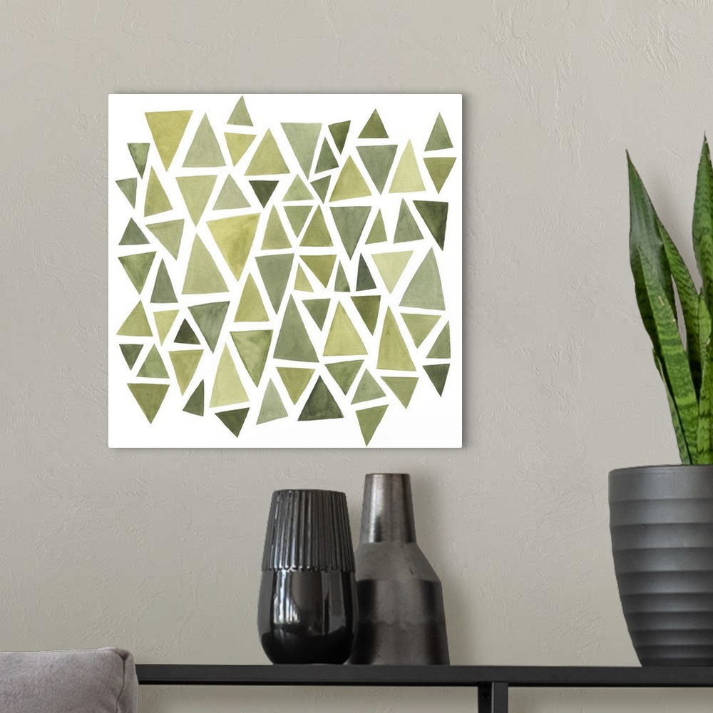 A modern room featuring A square decorative image of different sized triangles in varies shades of green on a white backg...