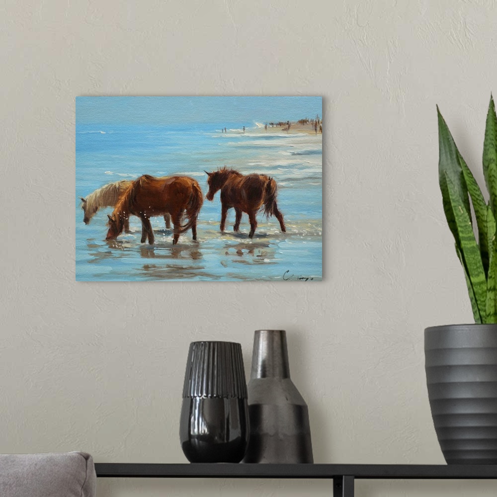 A modern room featuring A painting of horses on a beach wading through shallow water.