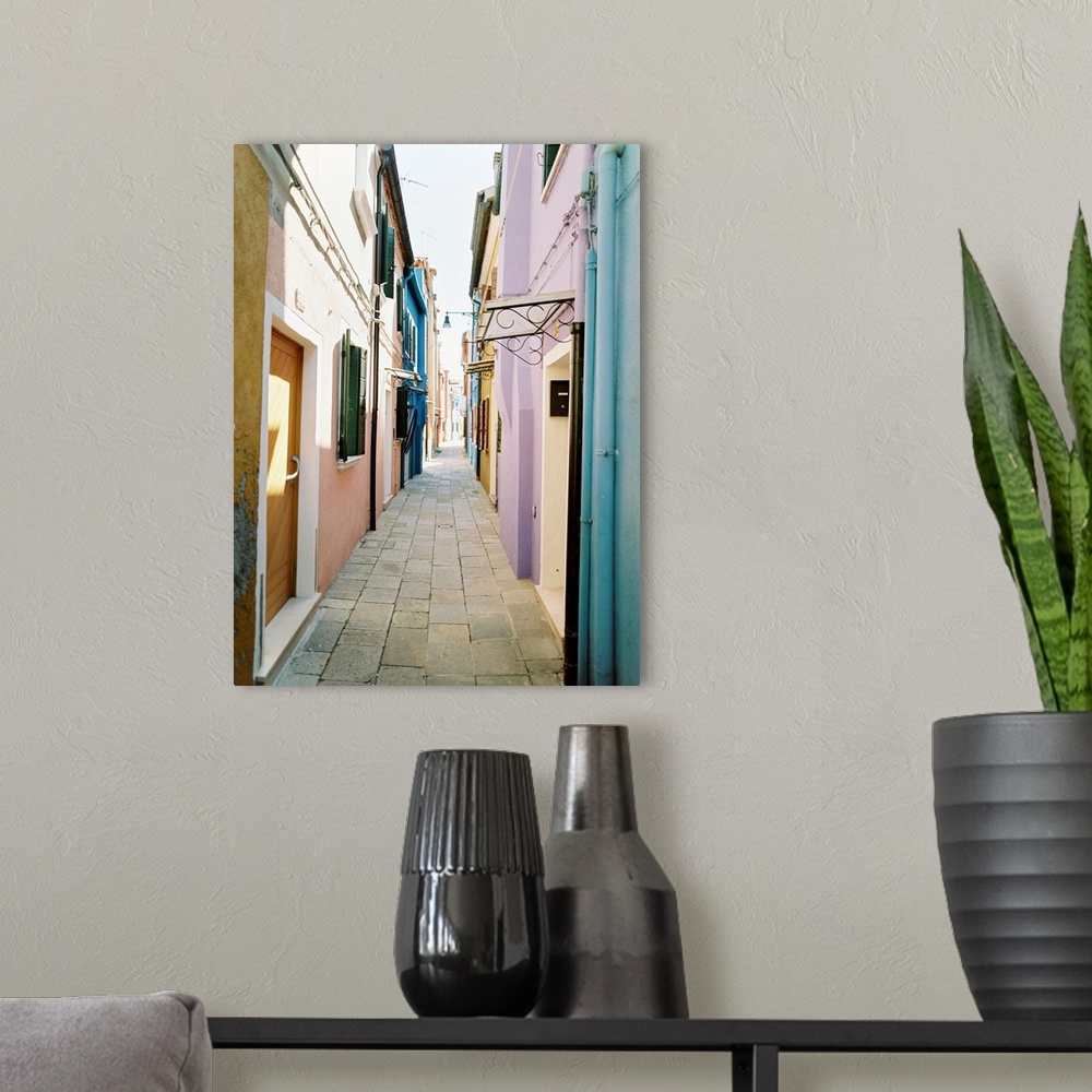 A modern room featuring Photograph of brightly painted houses in a narrow alleyway, Burano, Italy.