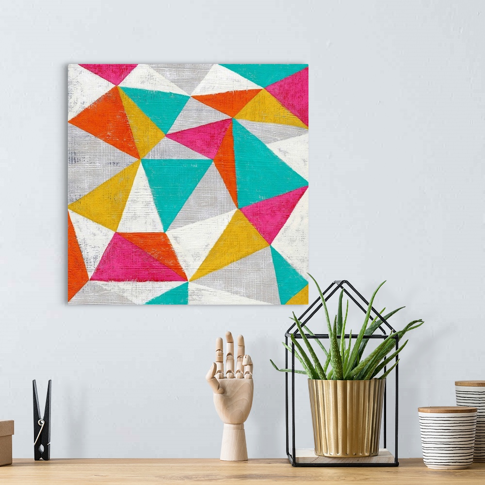 A bohemian room featuring Abstract geometric art in bright candy colored triangles.