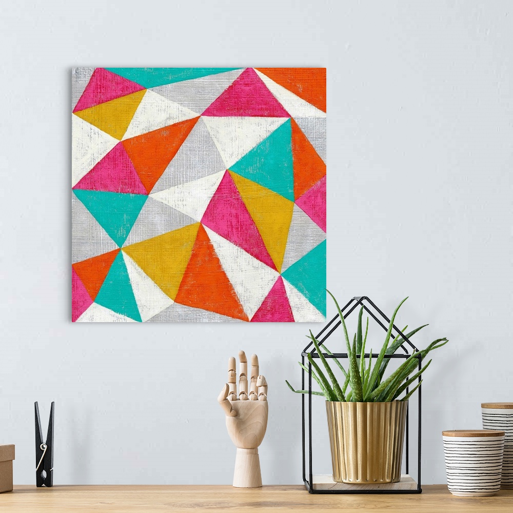 A bohemian room featuring Abstract geometric art in bright candy colored triangles.