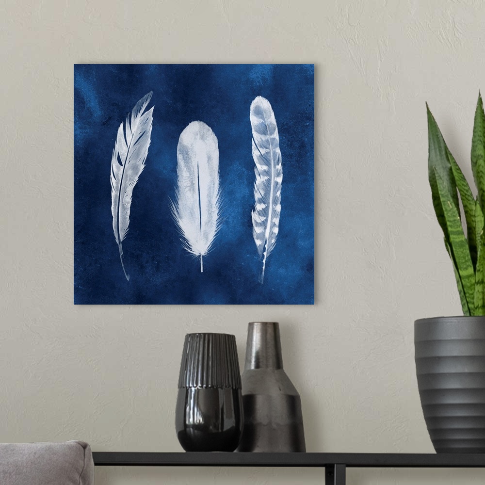 A modern room featuring Three white patterned feathers on a blue wash background, resembling a photo negative image.