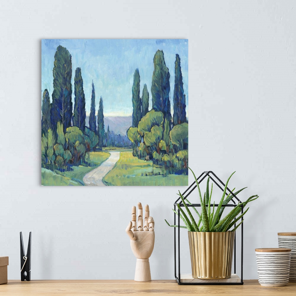 A bohemian room featuring Square painting of a green landscape filled with trees and a path leading to the background.