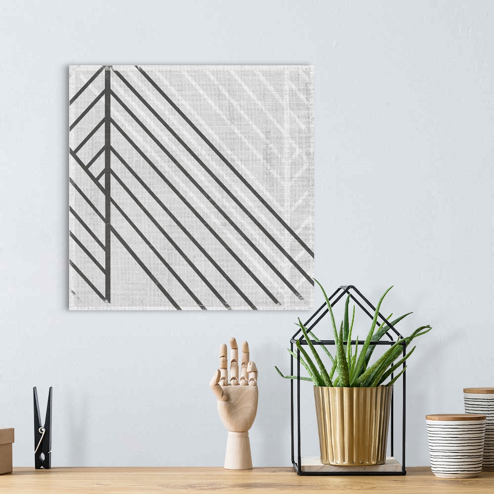 A bohemian room featuring Square abstract art with lines running diagonally across the canvas in gray and white.