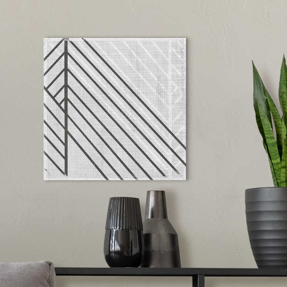 A modern room featuring Square abstract art with lines running diagonally across the canvas in gray and white.
