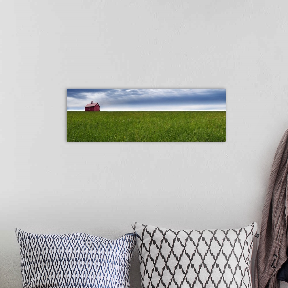 A bohemian room featuring Panoramic photograph of a rural landscape with a wide open green field, red barn, and a blue clou...