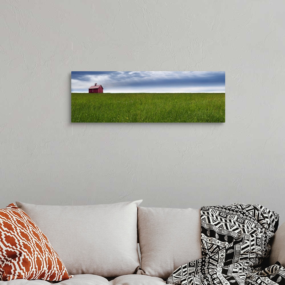 A bohemian room featuring Panoramic photograph of a rural landscape with a wide open green field, red barn, and a blue clou...