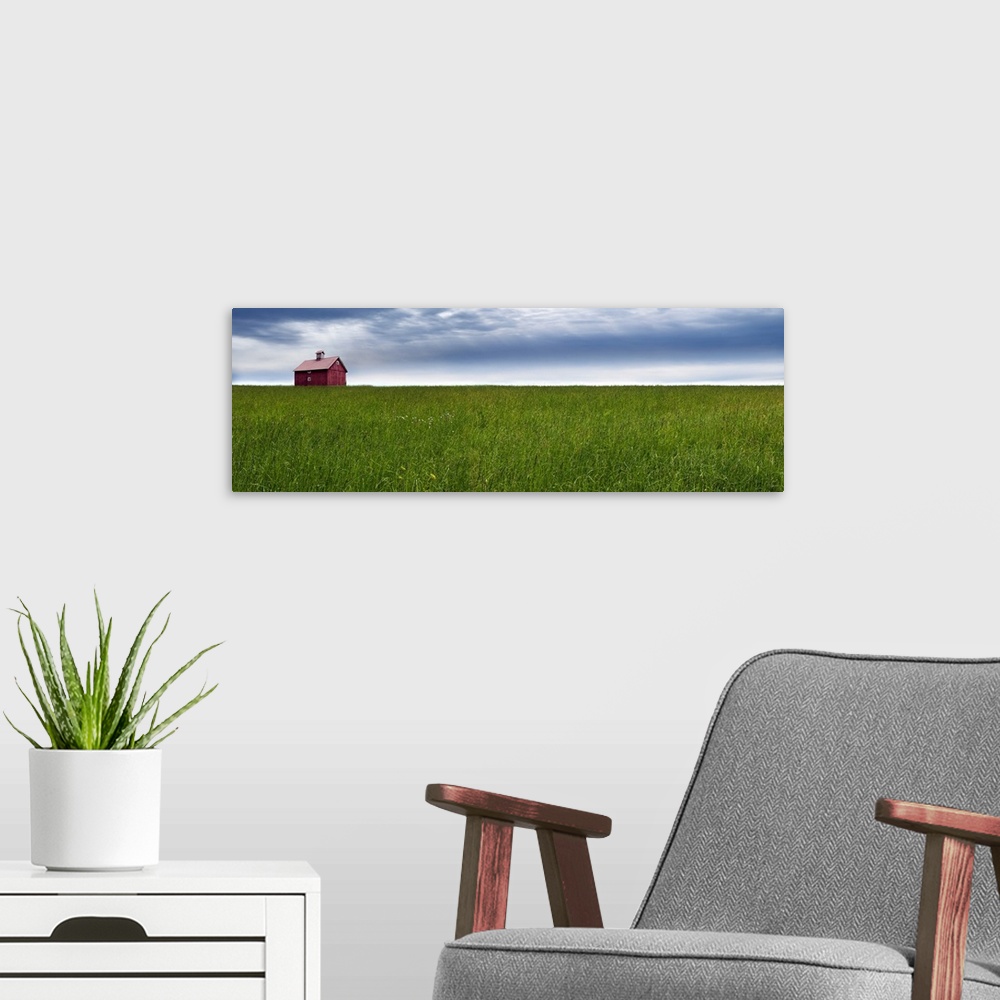 A modern room featuring Panoramic photograph of a rural landscape with a wide open green field, red barn, and a blue clou...
