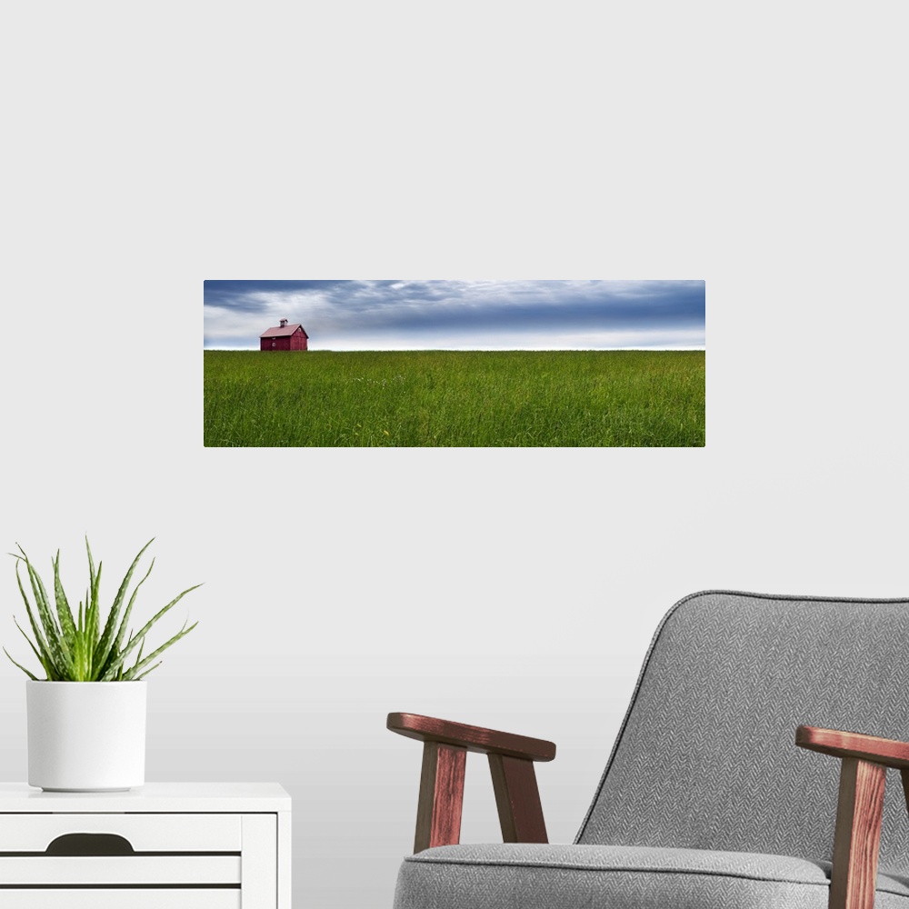 A modern room featuring Panoramic photograph of a rural landscape with a wide open green field, red barn, and a blue clou...
