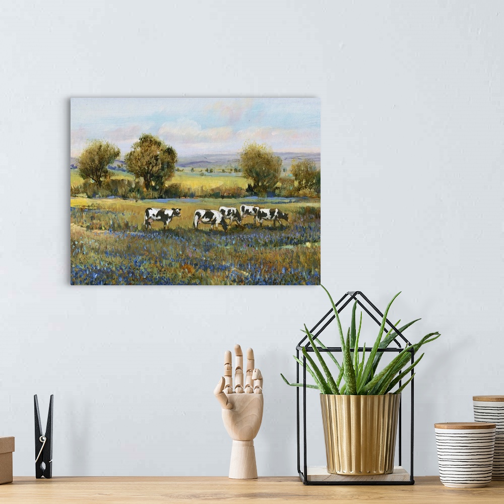 A bohemian room featuring Contemporary artwork of a calm countryside filled with grazing cows and blue flowers created with...