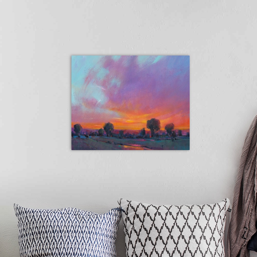 A bohemian room featuring Contemporary painting with vibrant oranges and yellows of a sun setting over the countryside.