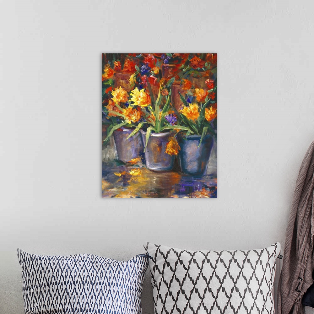 A bohemian room featuring Still life painting of three vases full of bright flowers.