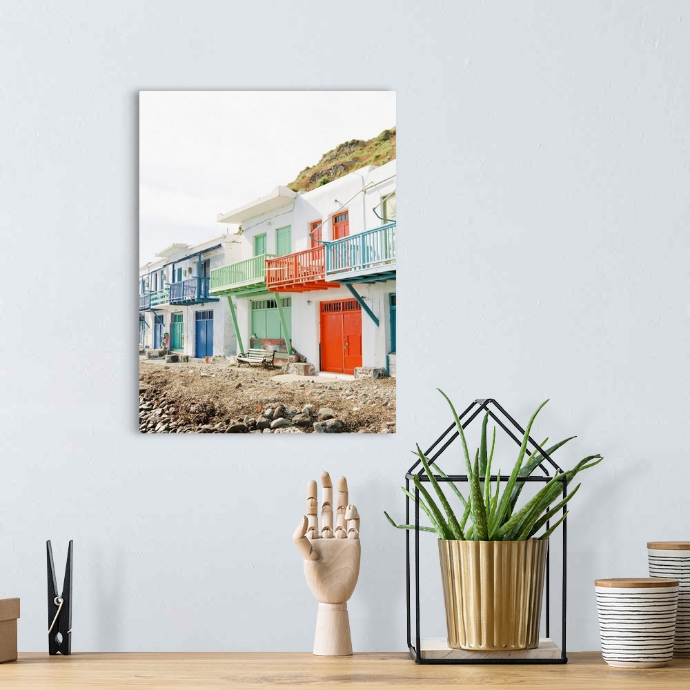 A bohemian room featuring Photograph of beach buildings in Milos, Greece, with colorfully painted doors and balconies.