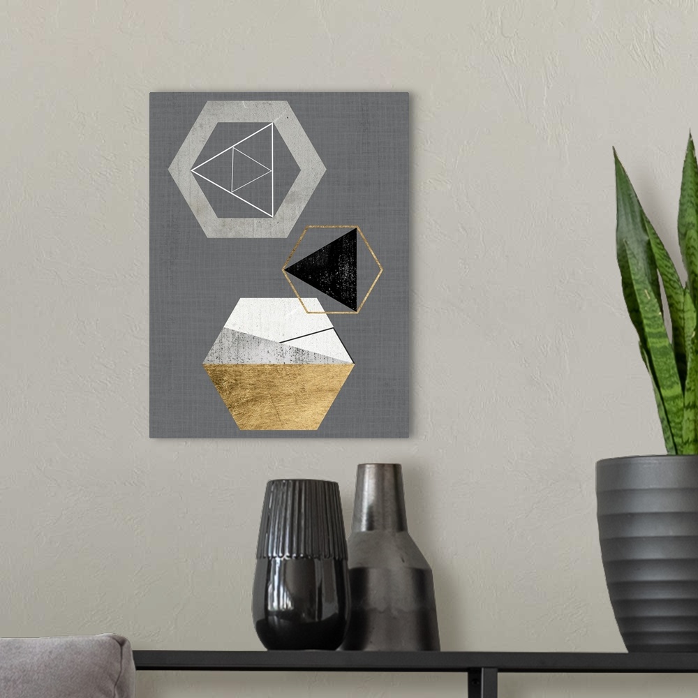 A modern room featuring Abstract geometric artwork of triangular and hexagonal shapes in grey and gold.