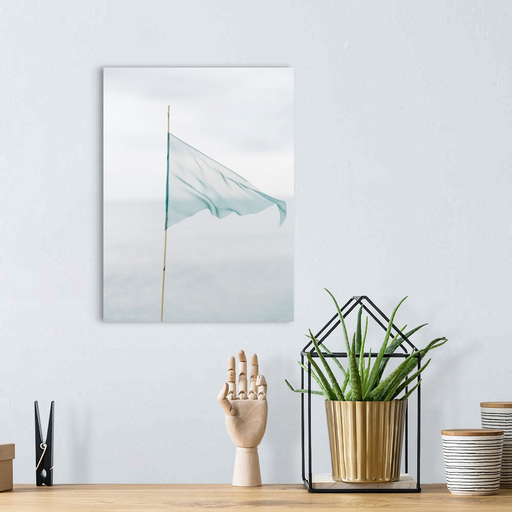 A bohemian room featuring Photograph of a delicate blue flag made from thin fabric on a bamboo pole.